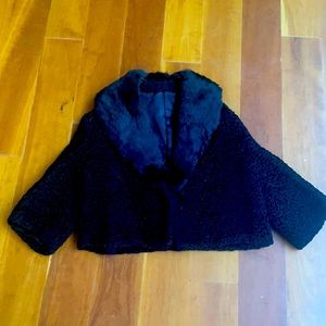 Black lambswool and fur; 42 in chest ;21 in in length; three-quarter sleeves